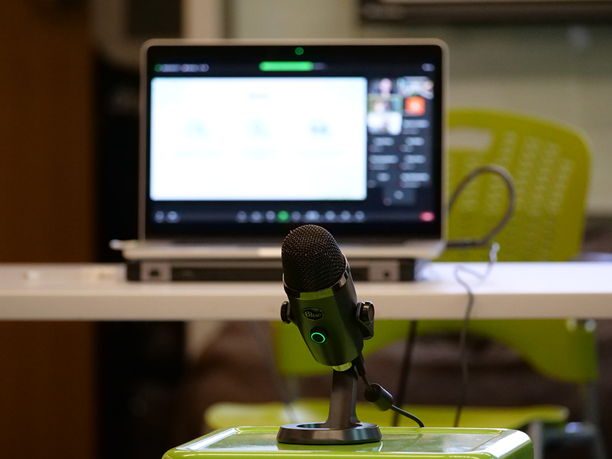 Microphone is placed on green stool for Zoom attendees to hear the discussion in the room.