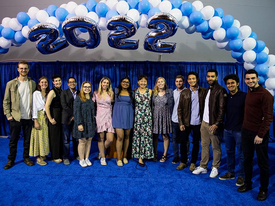Tufts Gordon Institute students posing for picture beneath "2022" balloons